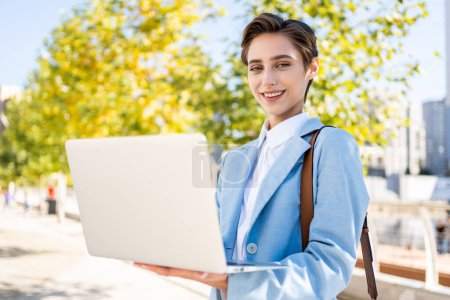 Photo for Beautiful young woman with short hair in the city - Pretty caucasian female adult business woman wearing elegant suit going to work in the office - Royalty Free Image