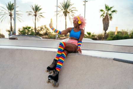 Belle femme patinant avec des patins à roulettes et s'amusant. Formation professionnelle de patineur et danseur le matin en portant des vêtements colorés et à la mode.