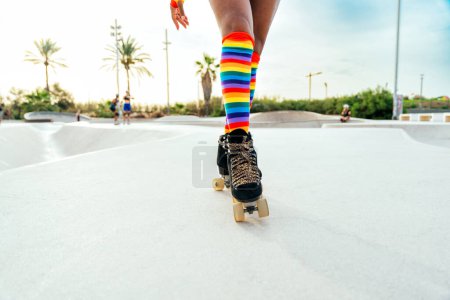 Hermosa mujer patinando con patines y divirtiéndose. Entrenamiento profesional de patinador y bailarín por la mañana con ropa de colores y de moda.