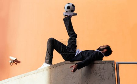 Foto de Imagen de un hombre de negocios y jugador de fútbol libre haciendo trucos con la pelota en la calle. Concepto sobre deporte y gente de negocios - Imagen libre de derechos