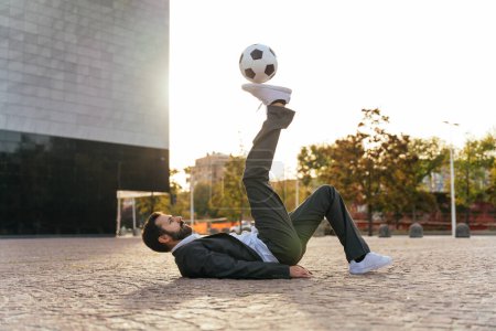Photo for Image of a businessman and soccer freestyle player making tricks with the ball on the street. Concept about sport and business people - Royalty Free Image