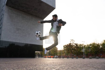 Foto de Imagen de un hombre de negocios y jugador de fútbol libre haciendo trucos con la pelota en la calle. Concepto sobre deporte y gente de negocios - Imagen libre de derechos