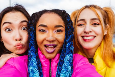 Photo for Multiracial group of young happy friends meeting outdoors in winter, wearing winter jackets and having fun - Multiethnic millennials bonding in a urban area, concepts about youth and social releationships - Royalty Free Image