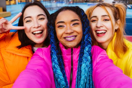 Téléchargez les photos : Groupe multiracial de jeunes amis heureux se réunissant à l'extérieur en hiver, portant des vestes d'hiver et s'amusant - Les milléniaux multiethniques se lient dans une zone urbaine, concepts sur les jeunes et les libérations sociales - en image libre de droit