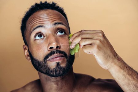 Photo for Image of a young man taking care of his skin. Beauty studio shot about skin care and products for the personal hygiene. - Royalty Free Image