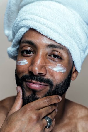 Téléchargez les photos : Image d'un jeune homme prenant soin de sa peau. Studio beauté tourné sur les soins de la peau et les produits pour l'hygiène personnelle. - en image libre de droit