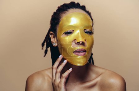 Foto de Hermosa mujer haciendo tratamientos de belleza facial y de piel. Estudio con enfoque en conceptos cosméticos y de cuidado de la piel - Imagen libre de derechos