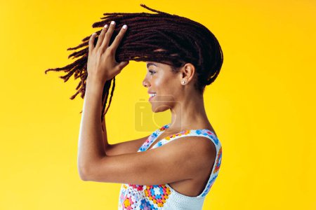 Foto de Imagen de una hermosa mujer joven posando sobre fondos de color con ropa de moda de colores. Concepto de despreocupación, moda y estilo de vida - Imagen libre de derechos