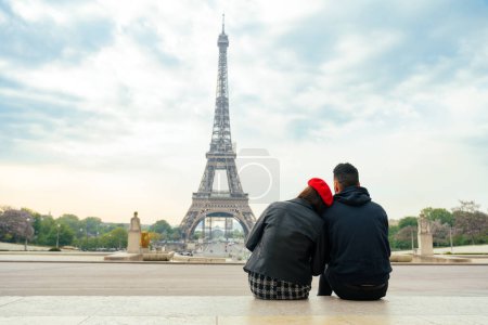 Téléchargez les photos : Cheerful happy couple in love visiting Paris city centre and Eiffel Tower . american tourists travelling in Europe and dating outdoors - en image libre de droit
