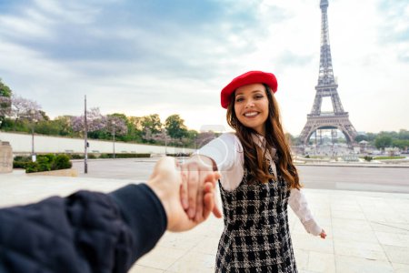 Téléchargez les photos : Cheerful happy couple in love visiting Paris city centre and Eiffel Tower . american tourists travelling in Europe and dating outdoors - en image libre de droit