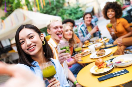 Téléchargez les photos : Multiracial young people together meeting and having party in a restaurant - Group of friends taking selfie while celebrating in a bar- Friendship and lifestyle concepts - en image libre de droit