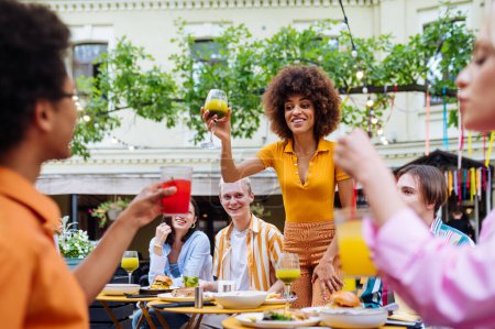 Foto de Multiracial young people together meeting and having party in a restaurant - Group of friends with mixed races having fun celebrating in a bar- Friendship and lifestyle concepts - Imagen libre de derechos