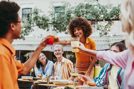 Foto de Multiracial young people together meeting and having party in a restaurant - Group of friends with mixed races having fun celebrating in a bar- Friendship and lifestyle concepts - Imagen libre de derechos