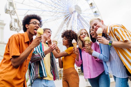 Photo for Multiracial young people together meeting at amusement park and eating ice creams - Group of friends with mixed races having fun outdoors - Friendship and lifestyle concepts - Royalty Free Image