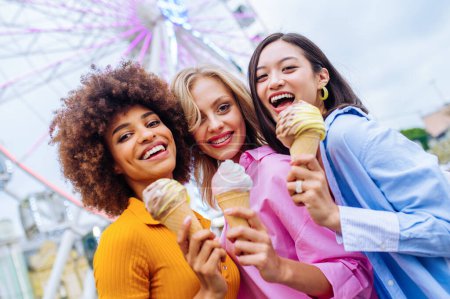 Foto de Multiracial young people together meeting at amusement park and eating ice creams - Group of friends with mixed races having fun outdoors - Friendship and lifestyle concepts - Imagen libre de derechos