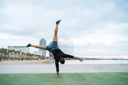 Photo for Sportive and athletic man doing functional training exercise at the outdoor gym - Adult athlete doing workout at sunrise at calisthenics park on the beach - Fitness, healthy lifestyle and sport concepts - Royalty Free Image