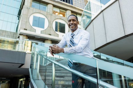 Foto de Handsome male african american business man CEO in a stylish corporate elegant suit in a business center outdoors - Black male commuter going to work, city and financial district in the background - Imagen libre de derechos