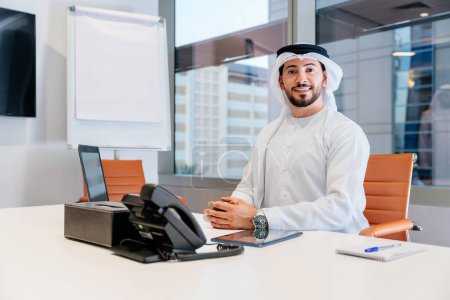Photo for Portrait of middle-eastern corporate businessman wearing kadora and working in the office in Dubai - Royalty Free Image