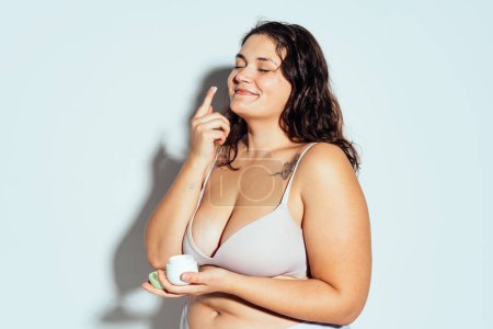 Plus Size Frau posiert im Studio in Dessous. Modell auf weißem Hintergrund. Hartes Licht Studio gedreht