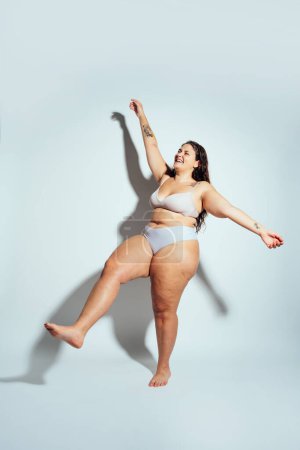 Téléchargez les photos : Femme de taille plus posant en studio en lingerie. Modèle sur fond blanc. Studio lumière dure tourné - en image libre de droit
