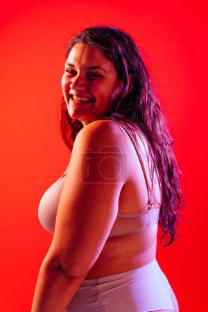 Téléchargez les photos : Femme de taille plus posant en studio en lingerie. Modèle sur fond coloré. Studio lumière dure tourné - en image libre de droit
