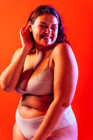 Foto de Mujer de talla grande posando en estudio en lencería. Modelo sobre fondo de color. Tiro de estudio de luz dura - Imagen libre de derechos