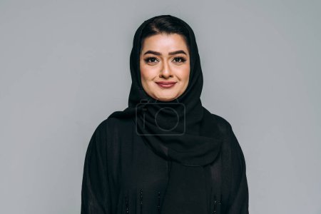 Schöne arabische Frau aus dem Nahen Osten mit traditionellem Abaya-Kleid im Atelier - arabisch-muslimische Erwachsenenporträt in Dubai, Vereinigte Arabische Emirate