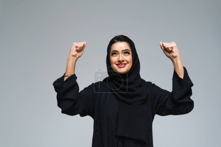 Photo for Beautiful arab middle-eastern woman with traditional abaya dress in studio - Arabic muslim adult female portrait in Dubai, United Arab Emirates - Royalty Free Image