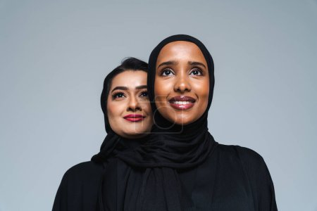 Schöne arabische Frauen aus dem Nahen Osten in traditioneller Abaya-Kleidung im Studio - arabisch-muslimische Erwachsenenporträt in Dubai, Vereinigte Arabische Emirate