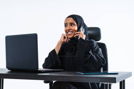 Téléchargez les photos : Belle femme d'affaires arabe du Moyen-Orient avec robe abaya traditionnelle travaillant dans le bureau Portrait féminin arabe musulman adulte au bureau informatique à Dubaï, Émirats arabes unis - en image libre de droit