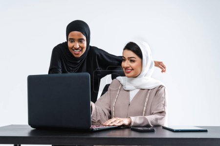 Téléchargez les photos : Belles femmes arabes du Moyen-Orient avec une robe abaya traditionnelle en studio - femmes d'affaires arabes musulmanes adultes travaillant ensemble dans le bureau de Dubaï, Émirats arabes unis - en image libre de droit