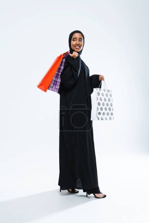 Photo for Beautiful arab middle-eastern woman with traditional abaya dress in studio - Arabic muslim adult female portrait in Dubai, United Arab Emirates - Royalty Free Image
