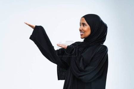 Téléchargez les photos : Belle femme arabe du Moyen-Orient avec robe traditionnelle abaya en studio - Portrait féminin arabe musulman adulte à Dubaï, Émirats arabes unis - en image libre de droit