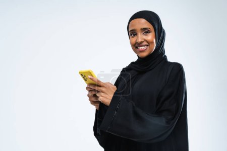 Téléchargez les photos : Belle femme arabe du Moyen-Orient avec robe traditionnelle abaya en studio - Portrait féminin arabe musulman adulte à Dubaï, Émirats arabes unis - en image libre de droit