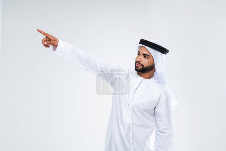 Photo for Handsome arab middle-eastern man with traditional kandora in studio - Arabic muslim adult male portrait wearing emirate clothing in Dubai, United Arab Emirates - Royalty Free Image