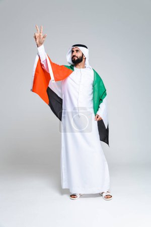 Foto de Hombre guapo árabe de Oriente Medio con kandora tradicional en el estudio - retrato masculino adulto musulmán árabe con ropa de emirato en Dubai, Emiratos Árabes Unidos - Imagen libre de derechos