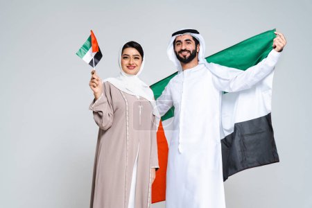 Téléchargez les photos : Magnifique couple arabe d'amoureux du Moyen-Orient vêtus d'abaya et de kandora traditionnels en studio - les adultes musulmans arabes se lient et s'amusent à Dubaï, Émirats arabes unis - en image libre de droit