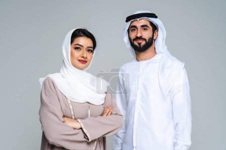 Téléchargez les photos : Magnifique couple arabe d'amoureux du Moyen-Orient vêtus d'abaya et de kandora traditionnels en studio - les adultes musulmans arabes se lient et s'amusent à Dubaï, Émirats arabes unis - en image libre de droit