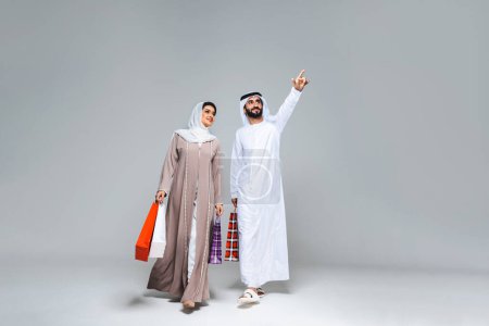 Photo for Beautiful arab middle-eastern happy couple of lovers wearing traditional abaya and kandora in studio - Arabic muslim adult people bonding and having fun in Dubai, United Arab Emirates - Royalty Free Image