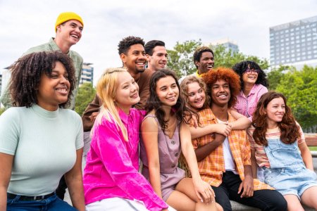 Foto de Feliz grupo multiétnico juguetón de jóvenes amigos que se unen al aire libre - Multiracial millennials estudiantes que se reúnen en la ciudad, conceptos de juventud, estilo de vida de las personas, diversidad, la vida adolescente y urbana - Imagen libre de derechos