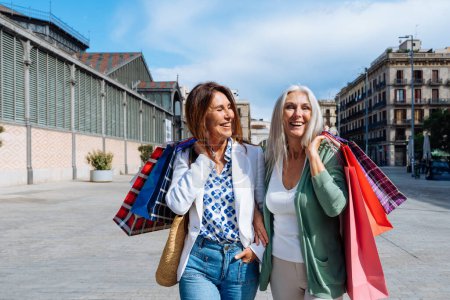 Photo for Beautiful senior women bonding outdoors in the city - Attractive cheerful mature female friends having fun, shopping and bonding, concepts about elderly lifestyle - Royalty Free Image