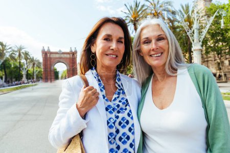 Schöne Seniorinnen im Freien in der Stadt - Attraktive, gut gelaunte, reife Freundinnen, die Spaß haben, einkaufen und zusammenleben, Konzepte über den Lebensstil älterer Menschen