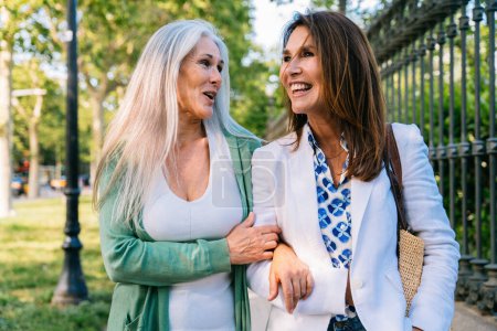 Photo for Beautiful senior women bonding outdoors in the city - Attractive cheerful mature female friends having fun, shopping and bonding, concepts about elderly lifestyle - Royalty Free Image