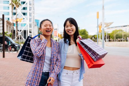 Photo for Happy beautiful chinese women friends bonding outdoors in the city - Playful pretty asian female adults meeting and having fun outside, concepts about lifestyle and friendship - Royalty Free Image