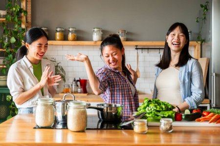 Photo for Happy beautiful chinese women friends bonding at home and cooking delicious meal together- Playful pretty asian female adults meeting and having fun at home, concepts about lifestyle, domestic life and friendship - Royalty Free Image
