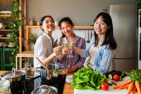 Foto de Feliz hermosa mujer china amigos que se unen en casa y cocinar deliciosa comida junto- Juguetón bastante asiática adultos se reúnen y se divierten en casa, conceptos sobre el estilo de vida, la vida doméstica y la amistad - Imagen libre de derechos