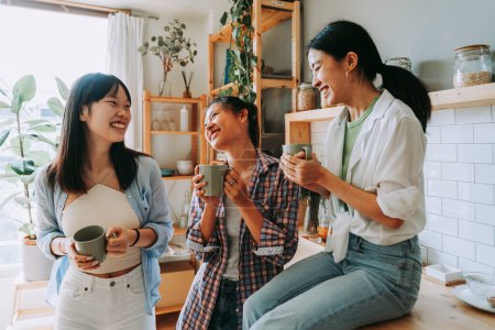 Téléchargez les photos : Bonnes amies chinoises heureuses se lient à la maison - Jolies adultes asiatiques ludiques se rencontrent et s'amusent à la maison, concepts sur le mode de vie, la vie domestique et l'amitié - en image libre de droit