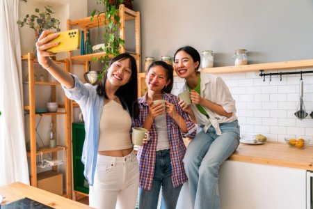 Téléchargez les photos : Bonnes amies chinoises heureuses se lient à la maison - Jolies adultes asiatiques ludiques se rencontrent et s'amusent à la maison, concepts sur le mode de vie, la vie domestique et l'amitié - en image libre de droit