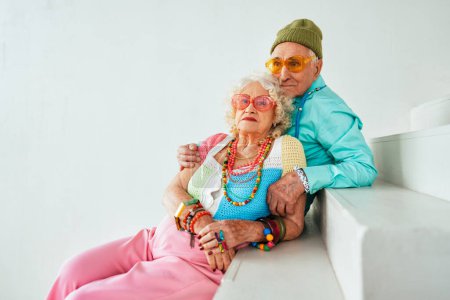 Photo for Beautiful senior old couple wearing fancy party clothes acting in studio on a colored background. Conceptual image about third age and seniority, old people feeling young inside. - Royalty Free Image