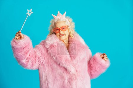 Photo for Beautiful senior old woman wearing fancy party clothes acting on a colored background in studio - Conceptual image about third age and seniority, old people feeling young inside. - Royalty Free Image